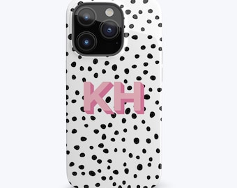 May include: A white phone case with black polka dots and the letters "KH" in pink.