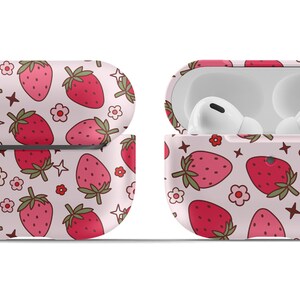 May include: A pink and white Airpods case with a strawberry pattern and a silver keychain.