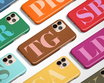 May include: Nine different iPhone cases with various colors and initials. The cases are all made of a hard plastic material and have a glossy finish.