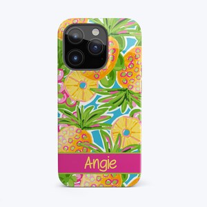 May include: A pink, green and yellow iPhone case with a pineapple pattern and the name "Angie" printed on the bottom.