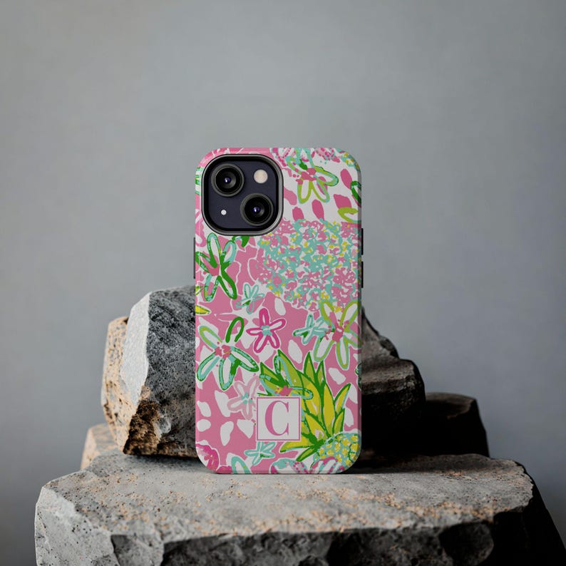 a pink phone case sitting on top of a rock
