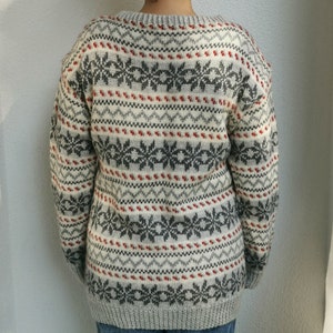 May include: A gray and white sweater with a red and gray snowflake pattern.