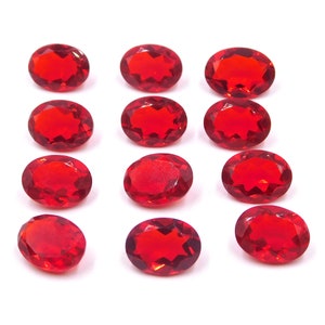 以下が含まれることがあります： ファセットカットされた、楕円形の赤い宝石が12個。宝石は3列4個ずつに並んでいます。