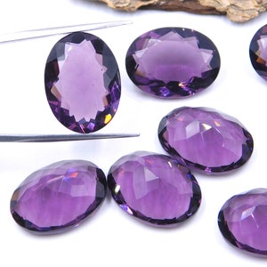 May include: Six oval-shaped amethyst gemstones with a faceted cut. The gemstones are a deep purple color and have a high shine.