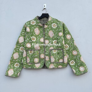May include: A green quilted jacket with a floral print and two pockets. The jacket has a mandarin collar and a button closure. The text "Fashionandfurnish" is printed on the front of the jacket.