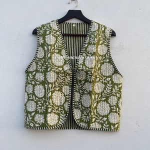 May include: A green quilted vest with a white floral print and a striped lining. The vest has a V-neck and a front zipper closure.