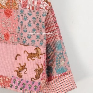May include: A pink and white patchwork quilt with a floral and tiger print. The quilt is made of cotton and is hand-stitched. The quilt is perfect for adding a touch of bohemian style to your home.
