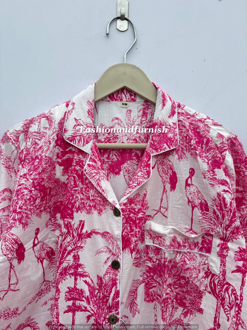 May include: White pajama top with a vibrant pink tropical print featuring flamingos, palm trees, and zebras. The top has a button-down front, a chest pocket, and white piping. The text "Fashionandfurnish" is visible on the collar.