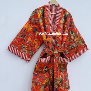 May include: A quilted red robe featuring a floral and bird design. The robe has a striped collar and cuffs, with pockets and a matching belt. The text "Fashionandfurnish" is visible on the robe.