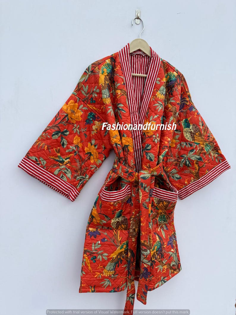 May include: A quilted red robe featuring a floral and bird design. The robe has a striped collar and cuffs, with pockets and a matching belt. The text "Fashionandfurnish" is visible on the robe.