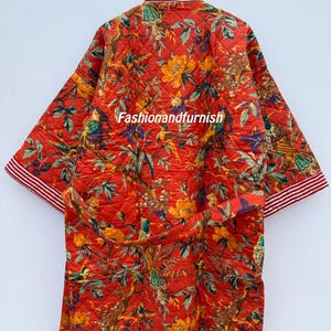 May include: Quilted red robe featuring a floral and bird design. The robe has a matching belt and white and red striped trim on the sleeves and collar. The text "Fashionandfurnish" is visible on the robe.