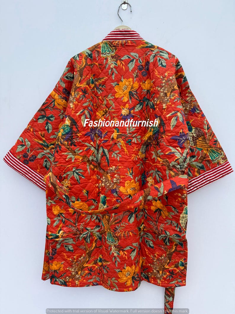 May include: Quilted red robe featuring a floral and bird design. The robe has a matching belt and white and red striped trim on the sleeves and collar. The text "Fashionandfurnish" is visible on the robe.