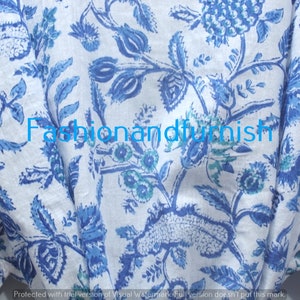 May include: White fabric with a blue floral pattern. The fabric has a blue and green floral design with a repeating pattern. The fabric is called "Fashionandfurnish".