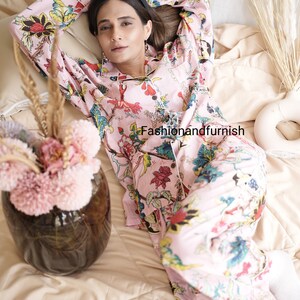 May include: A light pink long-sleeve pajama set featuring a vibrant floral and botanical print in shades of red, yellow, blue, and green. The button-down shirt has a collar and white piping. The text Fashionandfurnish is visible.