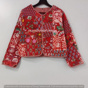 May include: A red quilted jacket with a floral print and white trim. The jacket has a button closure and long sleeves.