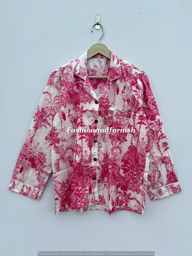 May include: White and pink pajama top with a botanical print featuring trees and birds. The long-sleeved shirt has a button-down front, a chest pocket, and white trim. The text "Fashionandfurnish" is visible.