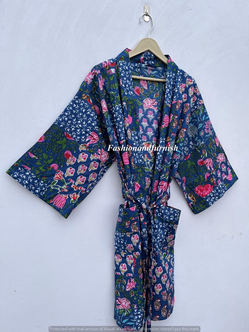 May include: A blue floral patterned robe with pink and green accents, hanging on a wooden hanger. The robe features a tie closure and pockets. The text "Fashionandfurnish" is visible on the robe.