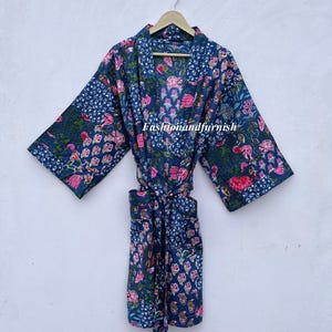 May include: A navy blue robe with a floral pattern in pink and green. The robe is hanging on a wooden hanger. The text "Fashionandfurnish" is visible on the robe.