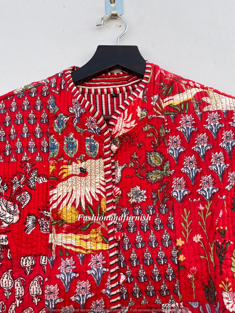 May include: Red quilted jacket with a floral print and a mandarin collar. The jacket has a striped lining and a button closure. The text "Fashionandfurnish" is visible on the jacket.