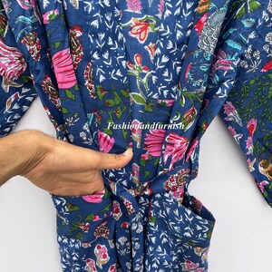 May include: A blue floral patterned robe with pink and red flowers and green leaves. The robe has a belt and pockets. The text "Fashionandfurnish" is visible on the robe.
