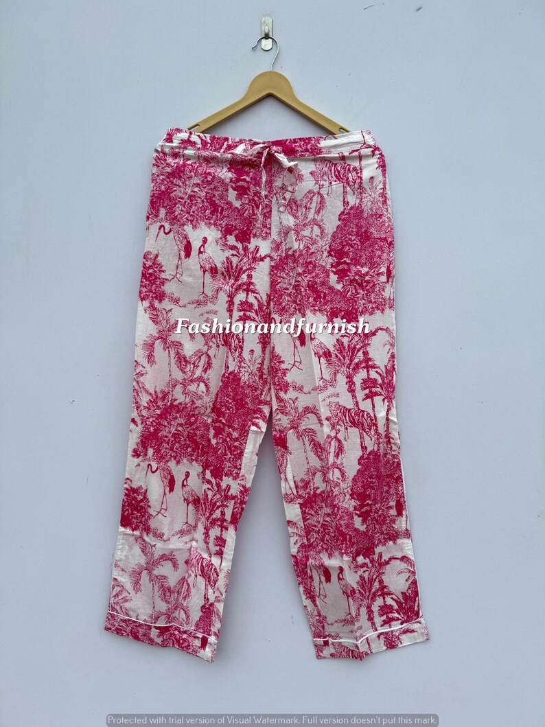 May include: White and pink pajama pants with a tropical print featuring trees, birds, and tigers. The pants have a drawstring waist and a white trim. The text "Fashionandfurnish" is visible on the pants.