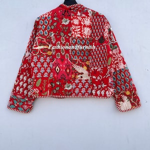 May include: Red quilted jacket with a floral print and white trim. The jacket has a mandarin collar and long sleeves. The text "Fashionandfurnish" is visible on the jacket.