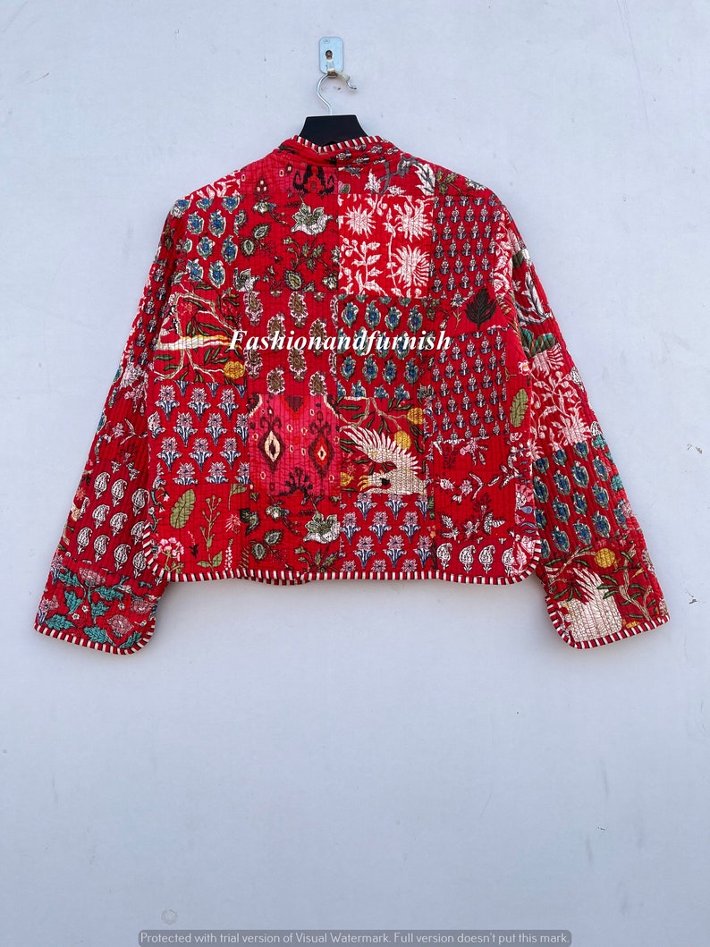 May include: Red quilted jacket with a floral print and white trim. The jacket has a mandarin collar and long sleeves. The text "Fashionandfurnish" is visible on the jacket.