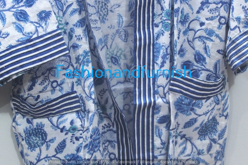 May include: A white cotton robe with a blue floral print and blue and white striped trim. The robe has a long sleeve and a tie closure.