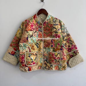 Könnte beinhalten: Gesteppte Jacke mit lebhaftem Blumenmuster in Rosa, Gelb und Grün. Die Jacke hat zwei Vordertaschen und gestreifte Manschetten. Der Text "Fashionandfurnish" ist auf der Jacke zu sehen.