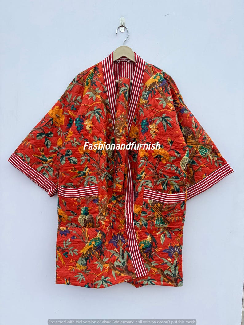 May include: A quilted red robe featuring a colourful bird and floral design. The robe has a striped trim and pockets. The text "Fashionandfurnish" is visible on the robe.
