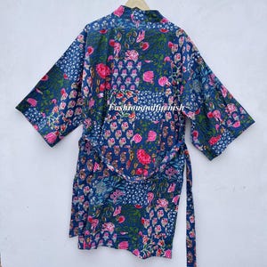 May include: A blue floral print kimono robe with a matching belt. The robe features a patchwork design with pink flowers and green leaves. The text "fashionandfurnish" is visible on the front of the robe.
