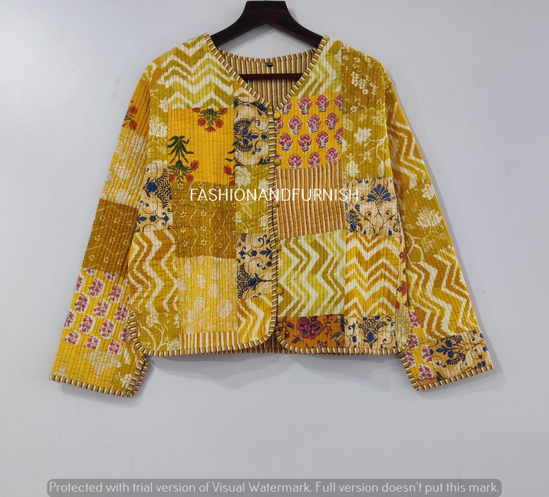 May include: A yellow quilted jacket with a patchwork design featuring various floral patterns. The jacket has a V-neck and a button closure. The text "FASHIONANDFURNISH" is visible on the front of the jacket.