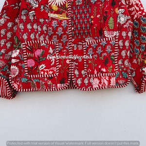 May include: A red quilted jacket with a floral print and a white trim. The jacket has a button closure and two pockets.