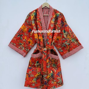 May include: A red quilted robe featuring a floral and bird design. The robe has a striped trim and a matching belt. The text "Fashionandfurnish" is visible. The robe is hanging on a wooden hanger.