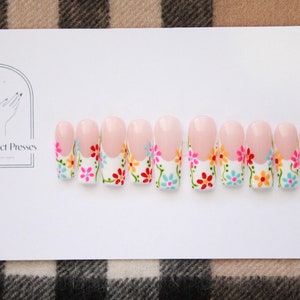 Witte French Tip kleurrijke lentebloemengelpers op nagels