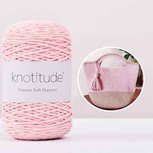 May include: A large spool of pink polyester soft macramé yarn with the brand name "knotitude" on the label. A crocheted pink and beige tote bag with a tassel is in a circular inset.