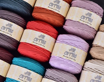 May include: Assortment of colorful macrame and knitting cotton yarn spools. The spools are in various colors, including teal, red, and lavender. Each spool has a label that reads "AIR COTTON Macrame & Knitting".