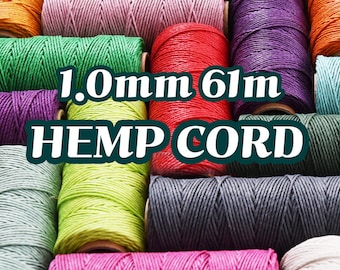 Puede incluir: Una colección de coloridas bobinas de hilo de cáñamo en varios tonos, incluyendo naranja, verde, morado y rosa. El texto "1.0mm 61m HEMP CORD" está presente. Las bobinas están bien enrolladas y dispuestas juntas.