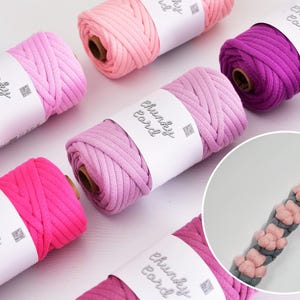 Può includere: Assortimento di rotoli di cordoncino spesso colorato in tonalità rosa e viola. Ogni rotolo è etichettato con la scritta "Chunky Cord". Un primo piano mostra un cordoncino grigio con accenti floreali rosa, che suggerisce un tema artigianale o fai-da-te.