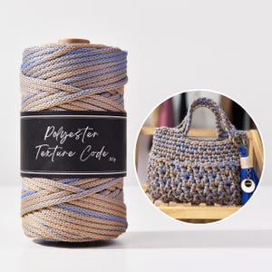 May include: A spool of beige and blue polyester yarn with the text "Polyester Texture Code" on a black label. A crocheted handbag in matching colours is also shown, with a blue tassel and charm.