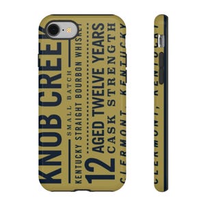 May include: A phone case with a tan background and navy blue text. The text reads "KNOB CREEK" and "12 AGED TWELVE YEARS CASK STRENGTH KENTUCKY". The case is designed to fit a smartphone.