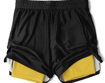 May include: Black athletic shorts with a yellow inner liner. The shorts have a drawstring waistband and a textured fabric.
