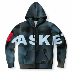 Peut inclure: Un sweat à capuche noir zippé avec un imprimé abstrait bleu et noir. Le mot "BASKET" est imprimé en blanc sur le devant du sweat. Le chiffre "3" est imprimé en rouge sur la manche gauche.