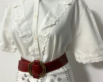 Camicetta in cotone bianco ricamata, colletto in pizzo sangallo, maniche a palloncino.