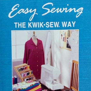 May include: A blue instructional sewing book titled Easy Sewing The Kwik-Sew Way Patterns Included by Kerstin Martensson. The cover features a magenta shirt on a dress form, a white sewing machine, a thread rack, and folded fabric stacks.