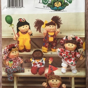 May include: A Butterick 3720 Cabbage Patch Kids sewing pattern envelope featuring illustrations of six dolls in various outfits, including a yellow jumpsuit, a sports-themed overall set, a floral dress with a matching hat, and a red jersey with the number 94.