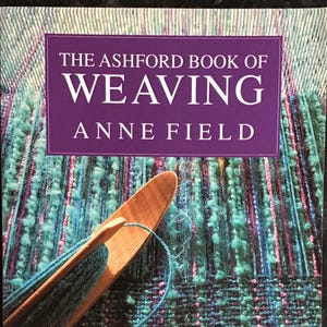 May include: The Ashford Book of Weaving by Anne Field, a book cover with a purple background and a close-up of a wooden weaving shuttle and colourful yarn.