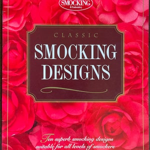 May include: A book cover with a red floral design. The title is "Classic Smocking Designs" with the subtitle "Ten superb smocking designs suitable for all levels of smockers".
