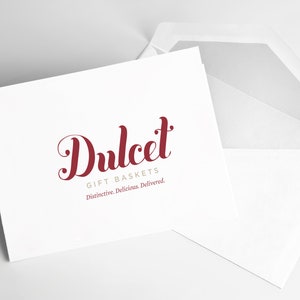 May include: A white card with a red cursive logo that says "Dulcet Gift Baskets" and the tagline "Distinctive. Delicious. Delivered."