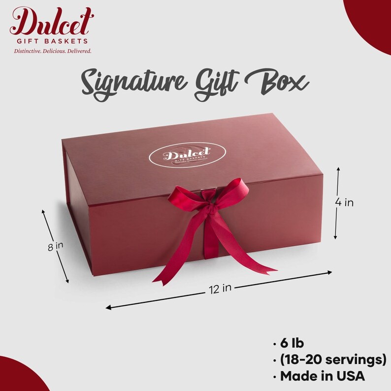 May include: A red gift box with a satin ribbon and bow. The box is 12 inches long, 8 inches wide, and 4 inches high. It contains a 6 lb gift basket with 18-20 servings. The box is labeled "Dulcet Gift Baskets" and "Signature Gift Box". Made in USA.